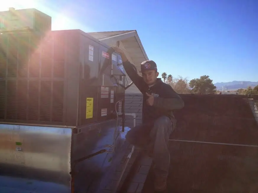 HVAC technician performing AC Tune-Up on a rooftop unit in Port Allen